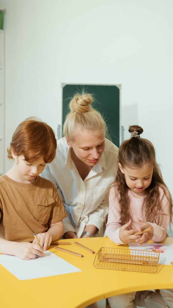 Teacher assists children in a classroom with learning activities.